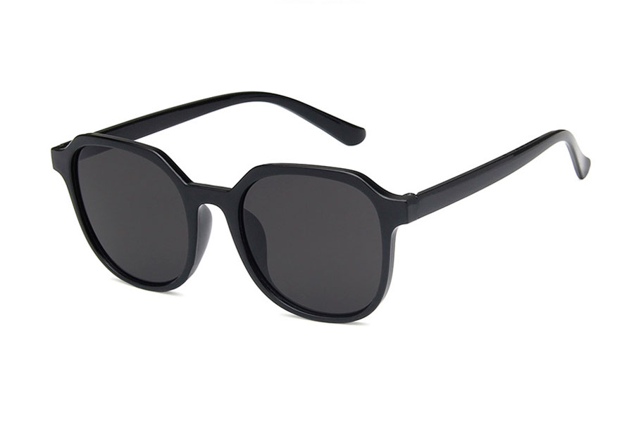 Dame solbrille i blank sort stel med grå-sorte glas. Formen er både lidt firkantet med runde former og rundt med kantede former | firkantet-solbriller
